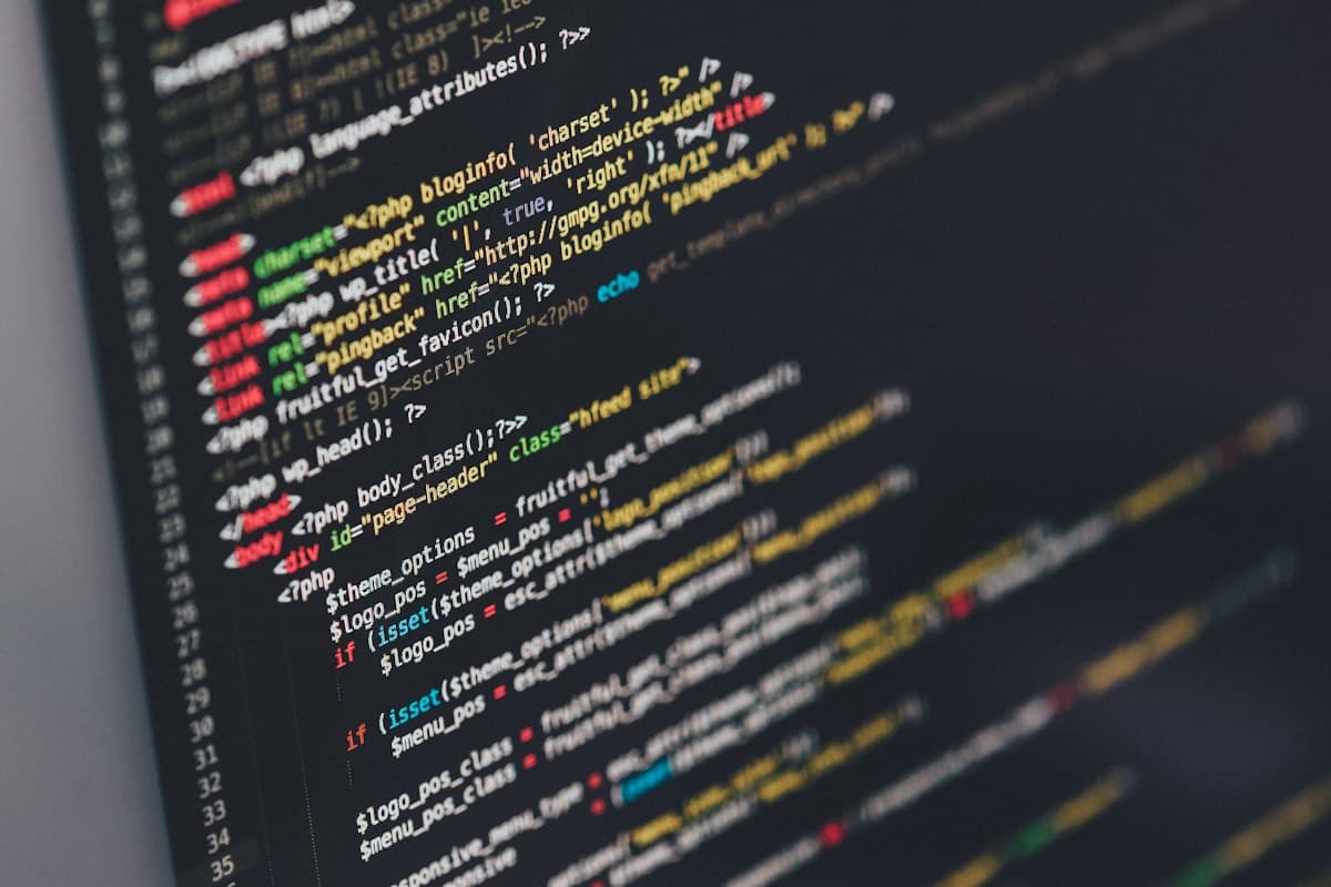 Developer writing code on a large monitor with syntax-highlighted editor